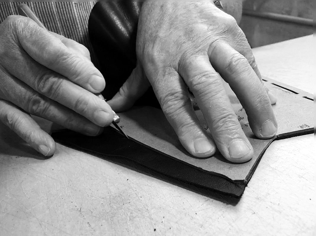 Hand-cutting leather along a pattern
