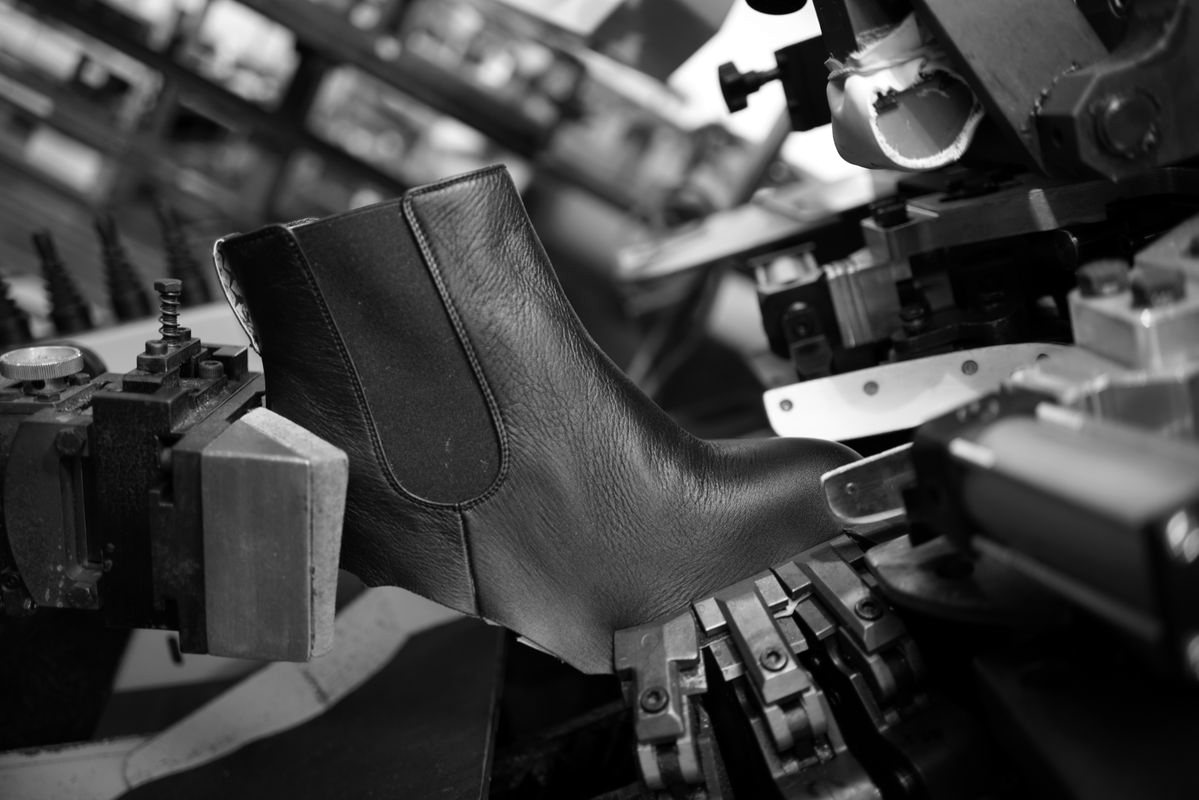 Black leather boot on a factory machine