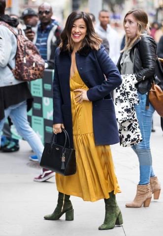 Guest in a navy coat, mustard dress and green suede ankle boots