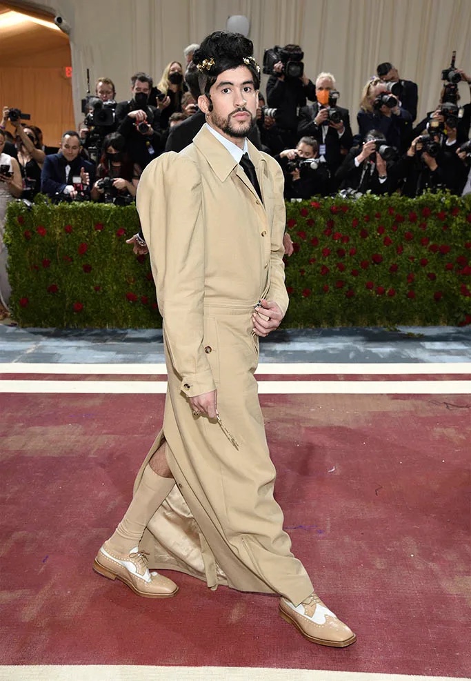 Guest in a long beige trench coat and two-tone brogues